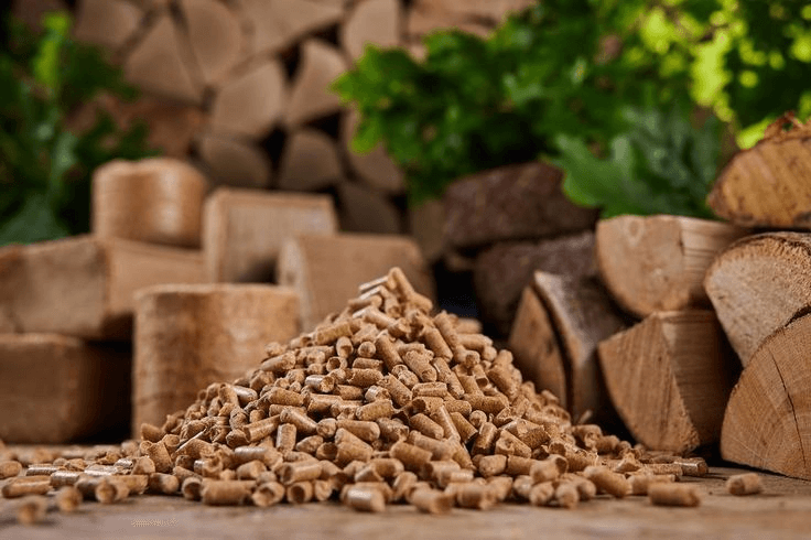 Pile of wood pellets with firewood in the background